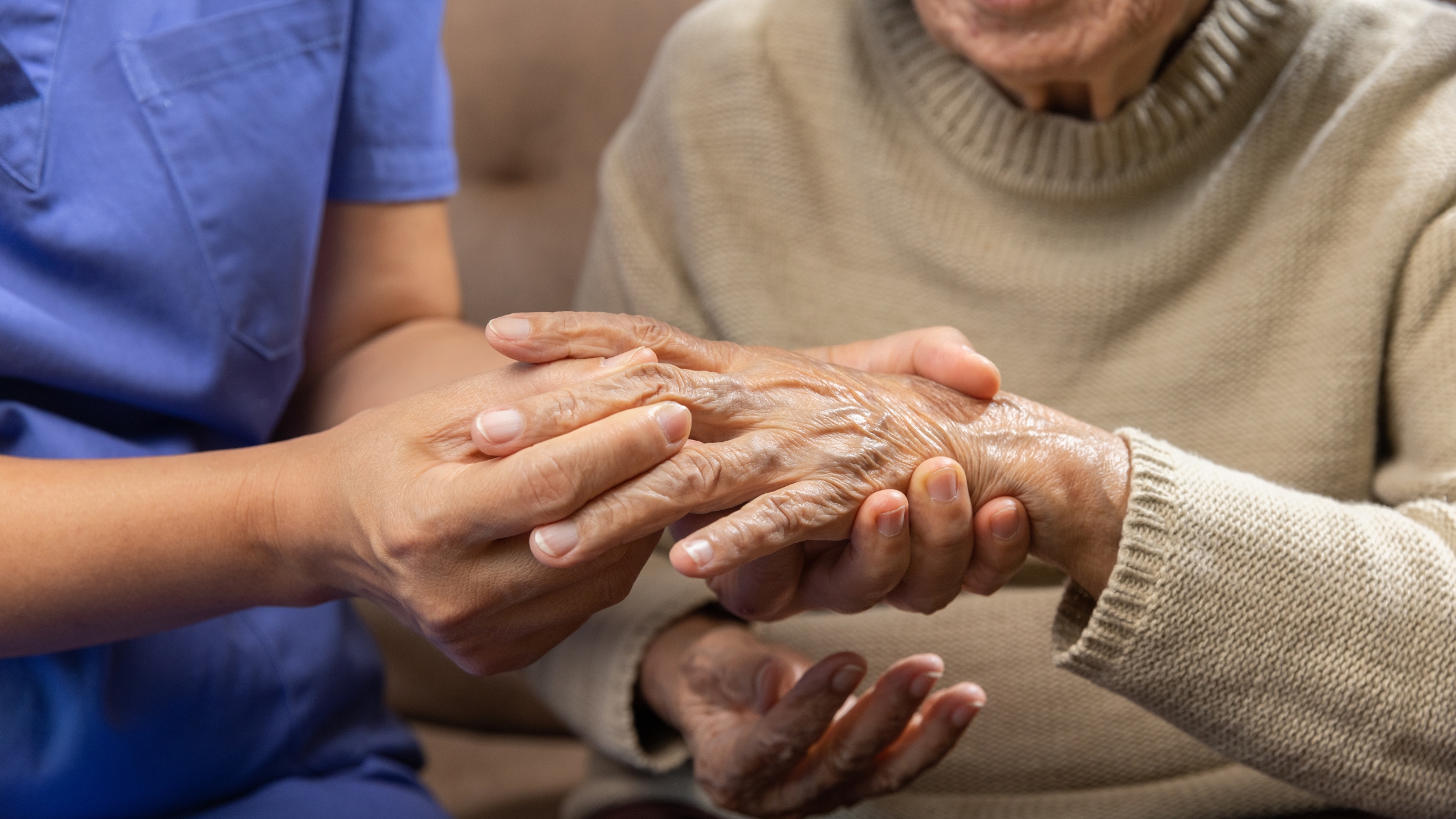 Caregiver holding an elderly woman hand