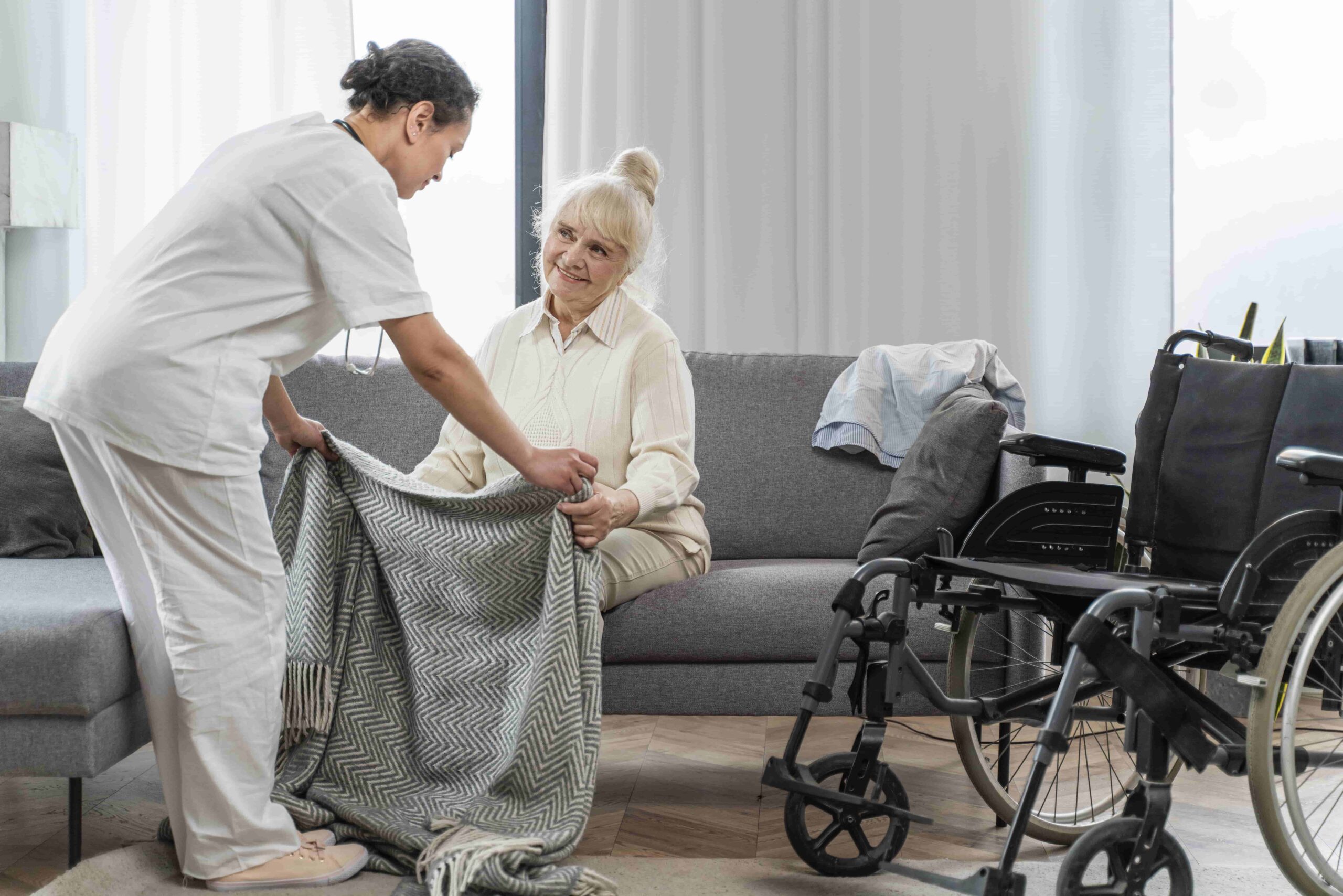 A woman in a wheelchair receives help from a nurse, showcasing the commitment to heart care assistance.